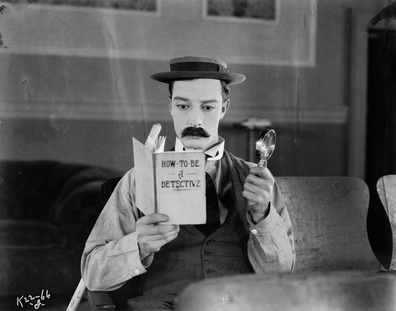 Americký komediant Buster Keaton s knihou 'How To Be A Detective' ve filmu Sherlock Junior